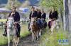 农牧民在鲁朗旅游小镇骑行（7月26日摄）。 新华社记者 张汝锋 摄