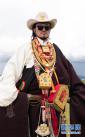 8月7日，一位身着色达传统藏族服饰的藏族小伙子在色达县扎青塘草原上。新华社记者 江宏景摄
