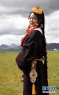 8月7日，一位身着色达现代藏族服饰的藏族姑娘在色达县扎青塘草原上。新华社记者 江宏景摄