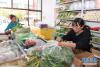 格桑旺姆（右）和姐姐德吉卓玛在位于白朗县的蔬菜店内忙碌（8月3日摄）。 新华社记者 李贺 摄