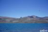 在西藏自治区的错那县，有一处澄澈的湖泊，浪涌着一下一下拍打着岸边的碎石，深蓝色的湖面如同天空翻转下来。抬眼望去，四周是白雪皑皑的高山，各色野花点点散落在草甸。它叫拿日雍错，意为“湖的前面”。