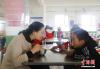 9月10日，青海省海南藏族自治州同德县贡麻小学，教师刘秀青和孩子们一起吃饭、聊天。