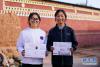 9月11日，在青海省化隆回族自治县金源藏族乡科上村，周毛卓玛和格热措（右）展示各自的大学录取通知书，姐妹俩分别被宝鸡文理学院和四川文化艺术学院录取。新华社记者 刘金海 摄