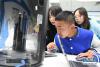 10月6日，在合肥启迪科技城，来自西藏山南市的学生边巴次仁（前）在了解3D打印知识。