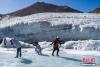 12月28日，为配合第七届全国大众冰雪季，在西藏自治区体育部门的组织下，约200名户外、冰雪运动爱好者齐聚位于拉萨市北部的洛堆峰，在专业教练的带领下，攀登至洛堆峰海拔5300米至5900米左右的位置，体验冬季雪山攀登乐趣。洛堆峰位于西藏拉萨市当雄县，海拔6010米，其雪面平缓、冰岩陡坡少，攀登难度较低。据悉，近年来，西藏自治区大力推广户外和冰雪运动，此次活动对于促进西藏冰雪运动发展，助力北京冬奥会，具有积极意义。图为参与者们在洛堆峰脚下的冰湖游玩。 中新社记者 何蓬磊 摄