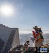 在西藏日喀则市桑珠孜区，藏族群众登高悬挂五彩经幡（1月15日摄）。新华社记者 孙非 摄