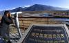 一名游客借助望远镜观看西藏雅尼国家湿地公园的景色（2月2日摄）。