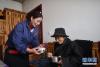 3月14日，幸福敬老院护工尼玛卓玛（左）为只沙群忠送餐。