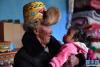 巴桑和九个月大的重外孙女白玛色珍在一起（3月21日摄）。新华社记者 孙瑞博 摄