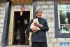 次仁老人抱着猫站在自家院中（4月16日摄）。新华社记者 孙瑞博 摄