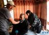  拉布老人的家人帮他整理藏装（4月25日摄）。新华社记者 普布扎西 摄