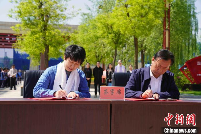 图为该活动组委会执行主席王清(左)与青海省三江源民族中学副校长李沛宇(右)签署捐赠协议书。　晚协 摄