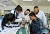 在西藏山南市第一高级中学，来自湖北襄阳的援藏老师蔡春亭（中）和本地老师次仁曲旦（右后）指导学生做化学实验（2019年5月7日摄）。新华社记者 张汝锋 摄