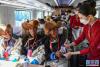 列车员向乘坐首趟复兴号高原内电双源动车组的乘客递水（6月25日摄）。新华社记者 普布扎西 摄