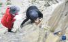8月21日，在西藏日喀则市一处山体，科考队员使用地质锤、罗盘等工具，进行地质灾害链科考工作。