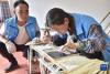 9月15日，西藏定结县陈塘镇农民、夏尔巴竹器手工艺传承人加布（左）指导村民用竹皮编织唐卡。新华社发（索朗罗布 摄）
