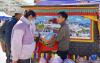 12月10日，在西藏康马县2021年产业竞赛暨冬季物资交流会上，来自拉萨的参展商（右）向顾客介绍工艺品。新华社记者 张汝锋 摄