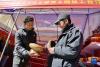 12月10日，在西藏康马县2021年产业竞赛暨冬季物资交流会上，来自山南市加查县冷达乡藏源木碗加工合作社的索朗扎堆（左）向顾客介绍木碗。新华社记者 张汝锋 摄