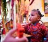 3月3日，在西藏拉萨，身着藏装的小姑娘在吃“切玛”。