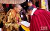 图为西藏自治区政协副主席、中国佛教协会西藏分会常务副会长、西藏佛学院院长珠康·土登克珠向获得学位的考僧献哈达，颁发学位证书。 中新社记者 贡桑拉姆 摄