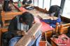图为5月8日，尼木县珍宝雕刻手工艺农牧民专业合作社的手工艺人在雕刻经板。 中新社记者 贡嘎来松 摄