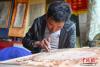 图为5月8日，尼木县珍宝雕刻手工艺农牧民专业合作社的手工艺人在雕刻文创产品。 中新社记者 贡嘎来松 摄