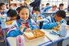 图为拉萨市实验小学东城分校小学生在享用营养午餐（5月12日摄）。记者 张汝锋 摄