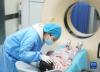 护士在安慰准备接受CT增强检查的小患者达瓦卓玛（5月12日摄）。
