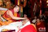 图为6月17日，班禅在西藏佛学院为僧人摸顶赐福。中新社发 李林 摄