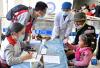7月9日，在西藏山南市浪卡子县人民医院，来自郑州市第七人民医院的志愿者张旗（前左）在为当地儿童做先心病筛查登记。
