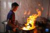 在拉萨市墨竹工卡县，洛桑益西在自己开的藏餐店内炒菜（6月23日摄）。新华社记者 姜帆 摄