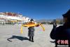 12月8日，西藏拉萨布达拉宫广场，来自四川甘孜的民众手捧哈达拍照留念。　李林　摄