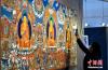12月19日，西藏拉萨，观众正在拍摄展览中的唐卡。