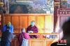12月27日，拉萨，信众正在大昭寺内供养佛像贴金。当日起，在暂停对外开放近五个月后，西藏大昭寺恢复对外开放。 中新社记者 贡嘎来松 摄