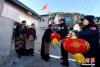图为西藏亚东出入境边防检查站副站长马岩（右二）为藏族老阿妈送上灯笼。 李林 摄