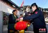 1月5日，移民警察为藏族老阿妈送上灯笼。李林 摄