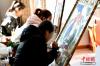 图为3月8日，西藏唐卡画院内正在绘制唐卡的女学生。