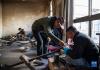 在扎西吉彩金银铜器厂，厂长拉巴琼达（前左）在指导年轻的手工艺人（3月9日摄）。新华社记者 孙非 摄
