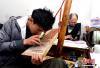 5月8日，手工艺人罗布正在西藏雪堆白技工学校里雕刻《大藏经》。中新社记者 李林 摄