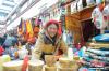 1月23日，在八廓商城卖年货的商贩尼玛次仁正在整理自己的商品。中新社记者 贡嘎来松 摄