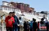 4月23日，游客在拉萨药王山观景台拍照留念。中新社记者 李林 摄