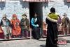 4月23日，身着藏装的游客在拉萨八廓街拍照留念。中新社记者 李林 摄