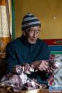 次仁老人在拉萨市当雄县宁中乡麦灵村的家里吃风干牦牛肉（4月16日摄）。新华社记者 孙瑞博 摄