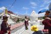 图为4月29日，游客在拉萨药王山观景台身着藏族传统服饰拍照留念。　 中新社发 贡嘎来松 摄