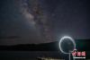 7月17日晚，游客在西藏羊卓雍错湖畔进行光绘摄影，远处便是浩瀚银河。