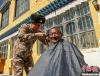 图为阿里军分区某边防团官兵为驻地群众理发迎藏历新年。　旦增伦珠 摄