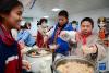 2月21日，在西安市浐灞第一中学举行的藏历新年团拜活动上，学生品尝特色小吃。新华社记者 李一博 摄