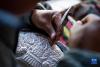 在扎西吉彩金银铜器厂，一名手工艺人在给银器錾刻花纹（3月9日摄）。新华社记者 孙非 摄