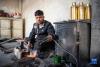 在扎西吉彩金银铜器厂，一名手工艺人在煅烧银片（3月9日摄）。新华社记者 孙非 摄