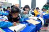 3月14日，西藏拉萨市第一小学一年级六班学生白玛朗珍(图左)在藏语文课上书写藏文。　李林 摄
